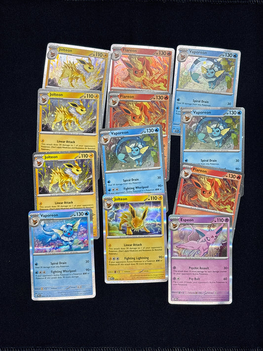 Auction Lot 33: Pokemon Prismatic Evolutions 12x Cosmo and Holo Rare Lot Conditions Vary